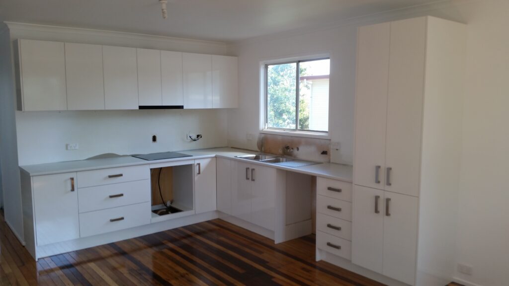 Gloss white melamine kitchen with postformed laminate bench top.