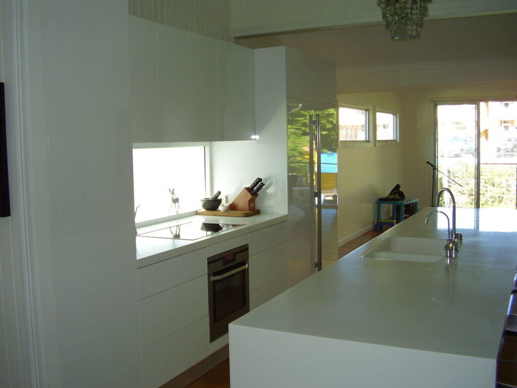 White kitchen lit up by splash back window at bench height.